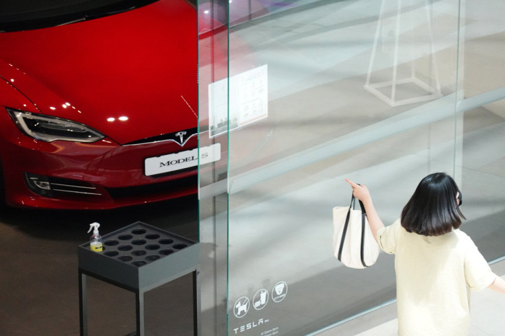 Una donna passa davanti a un concessionario Tesla ad Hanam