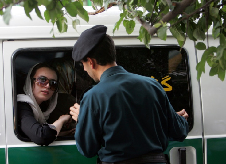 Un ufficiale iraniano (R) parla con una donna arrestata per aver indossato abiti "inappropriati" a Teheran, il 23 luglio 2007