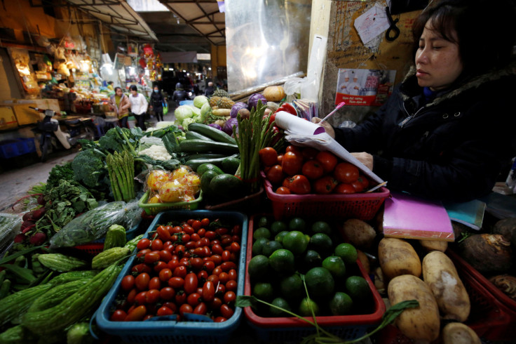 Una donna vende verdure in un mercato di Hanoi