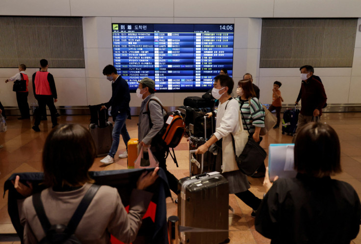 I passeggeri camminano al loro arrivo all&#39;aeroporto internazionale di Haneda mentre il Giappone riapre per i viaggi senza visto a Tokyo