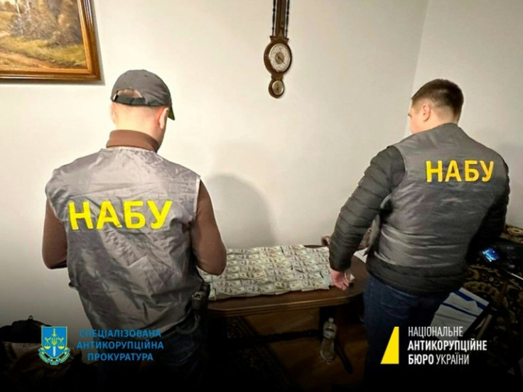 Una fotografia distribuita dall&#39;Ufficio nazionale anticorruzione dell&#39;Ucraina mostra i membri dello staff della NABU accanto al denaro sequestrato