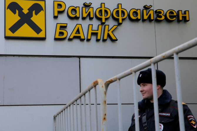 L&#39;ufficiale di polizia russo si trova di fronte alla filiale della Banca Raiffeisen a Mosca