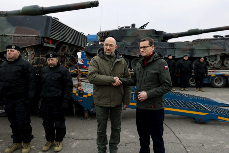 Il primo ministro ucraino Shmyhal e il primo ministro polacco Morawiecki si stringono la mano accanto ai primi carri armati Leopard 2 consegnati dalla Polonia, in una località sconosciuta in Ucraina