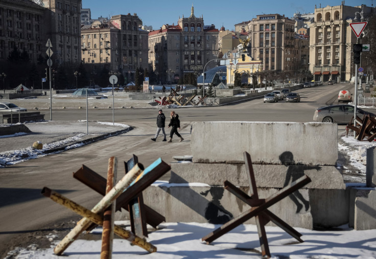 La gente cammina lungo una strada vicino alle costruzioni anticarro nel centro di Kiev