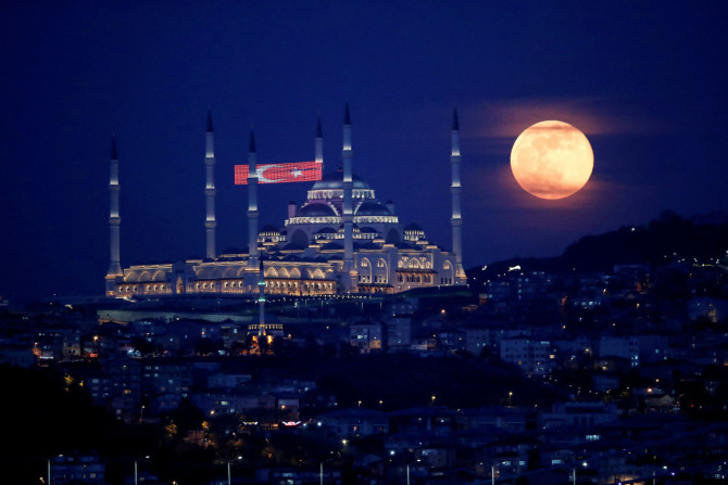 La luna piena, nota anche come Supermoon o Flower Moon, sorge sopra la Moschea Camlica durante la diffusione della malattia da coronavirus (COVID-19), a Istanbul