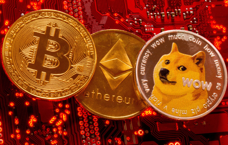 Le rappresentazioni delle criptovalute Bitcoin, Ethereum e DogeCoin sono posizionate sulla scheda madre del PC in questa illustrazione presa