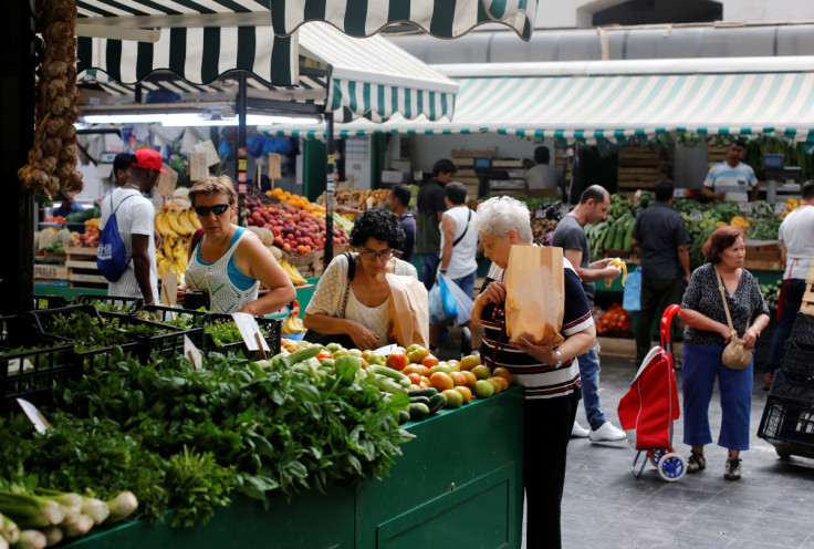 La gente fa acquisti in un mercato di frutta e verdura nel centro di Roma