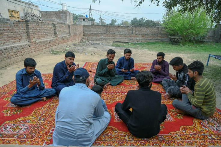 Persone in lutto pregano per Muhammad Nadeem, vicino alla sua casa nel distretto di Gujrat