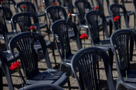 Garofani sono posti su cinquantasette sedie, che rappresentano le vittime di un fatale incidente ferroviario nei pressi della città di Larissa, durante una manifestazione davanti al Ministero dei Trasporti ad Atene