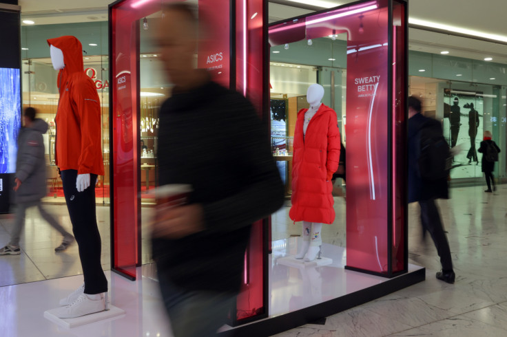 La gente passa davanti ai manichini in un centro commerciale