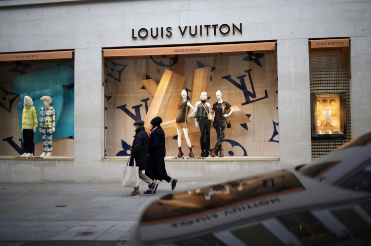 La gente cammina fuori da un negozio Louis Vuitton su New Bond Street a Londra