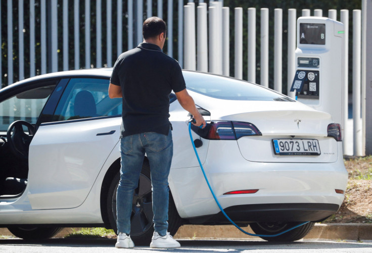Un uomo rimuove un cavo dopo aver caricato un&#39;auto elettrica Tesla a Sant Cugat del Valles, vicino a Barcellona