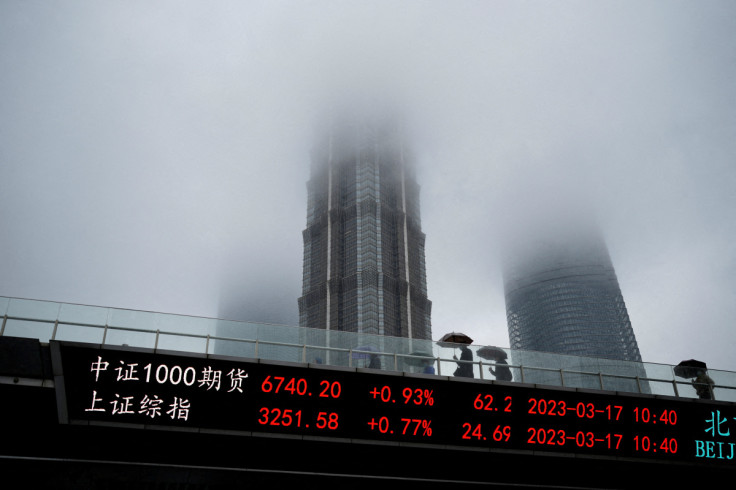 Una lavagna elettronica mostra gli indici azionari del distretto finanziario di Lujiazui a Shanghai