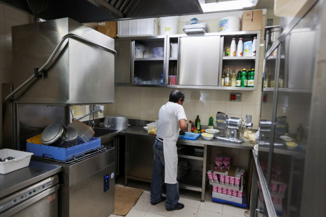 Migranti al lavoro nella cucina di un ristorante milanese