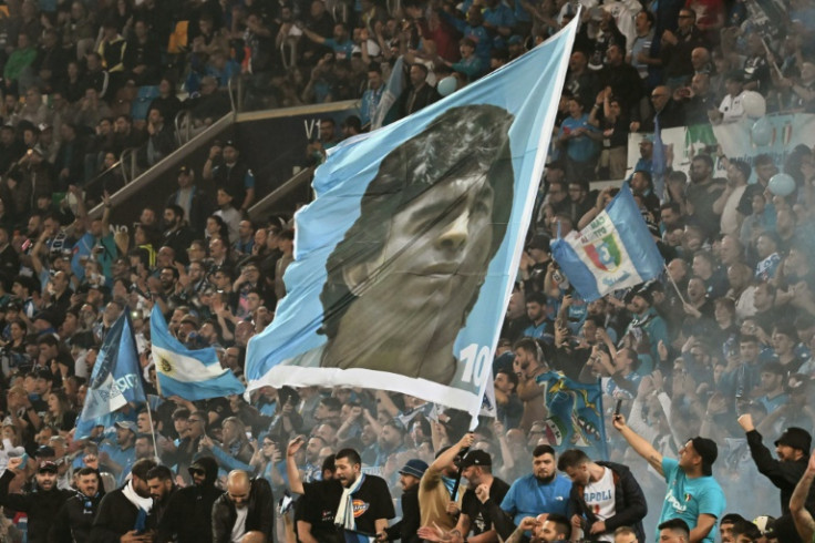 I tifosi del Napoli sventolano una bandiera gigante di Diego Maradona, che ha portato il club ai suoi primi due titoli