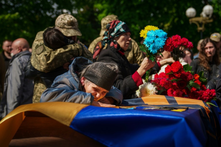 Una donna anziana piange sulla bara del militare ucraino morto vicino a Bakhmut