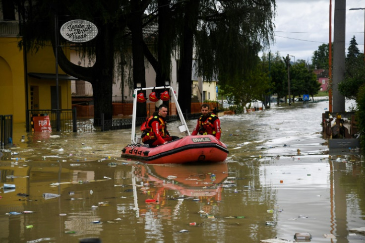 I vigili del fuoco volontari guidano il loro gommone attraverso una strada allagata dal fiume Savio nel quartiere Ponte Vecchio di Cesena, il 17 maggio 2023