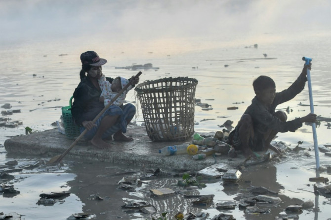 Raccoglitori di rifiuti alla ricerca di plastica e vetro da riciclare a Pazundaung Creek, Yangon