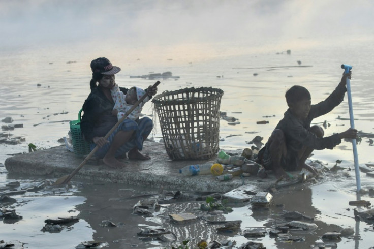 Raccoglitori di rifiuti alla ricerca di plastica e vetro da riciclare a Pazundaung Creek, Yangon
